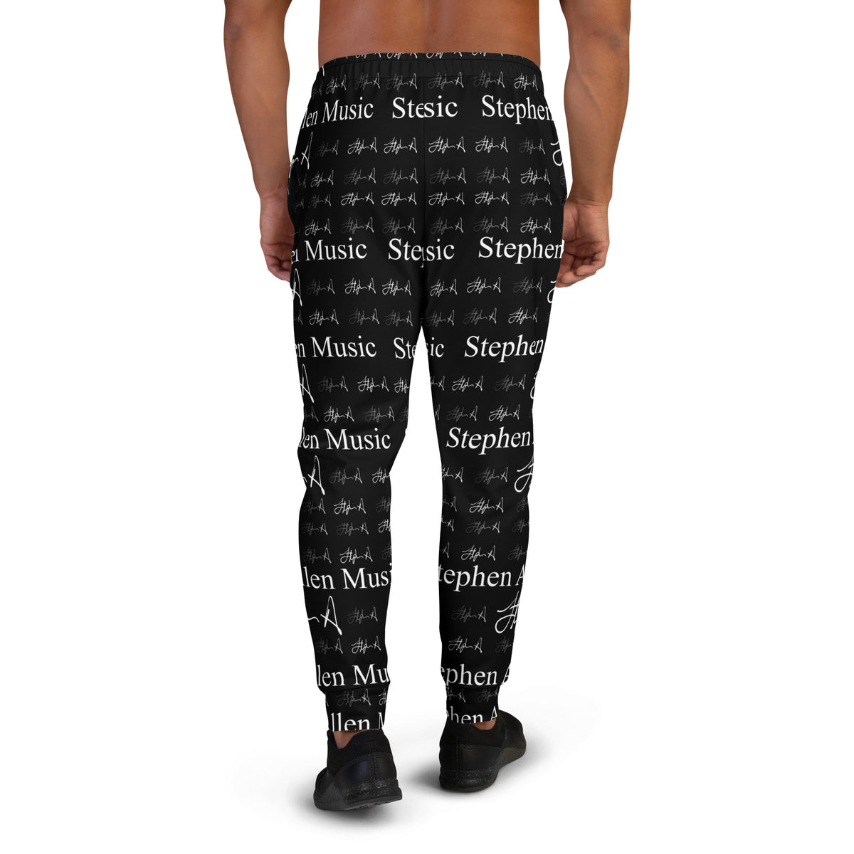 A person wearing black jogger-style pants with an allover white 'Stephen Allen Music' text and script print, shown from the waist down against a plain white background.