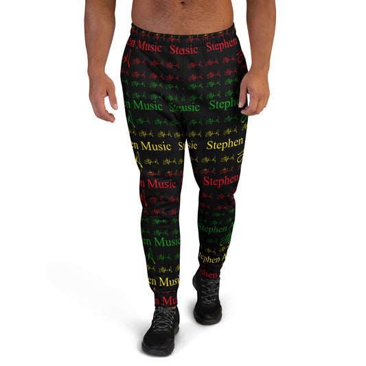 A person modeling black jogger-style pants with an allover repeating pattern of red, green, and yellow text and symbols on a white studio background. Stephen Allen Music