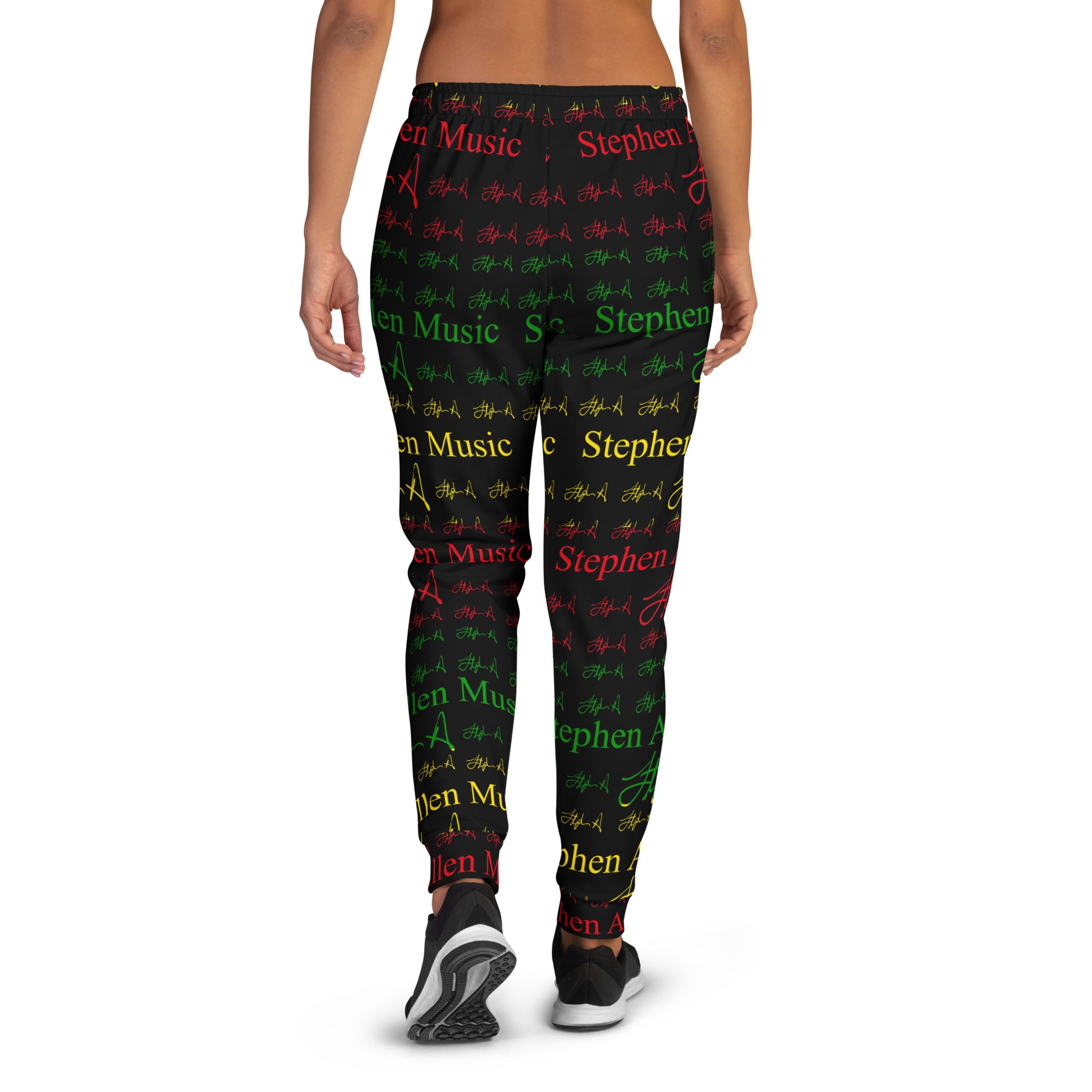 A person modeling patterned leggings against a plain white studio background. The leggings feature an all-over print of the phrase 'Stephen Allen Music' in red, green, and yellow text with repeated signature-style marks.