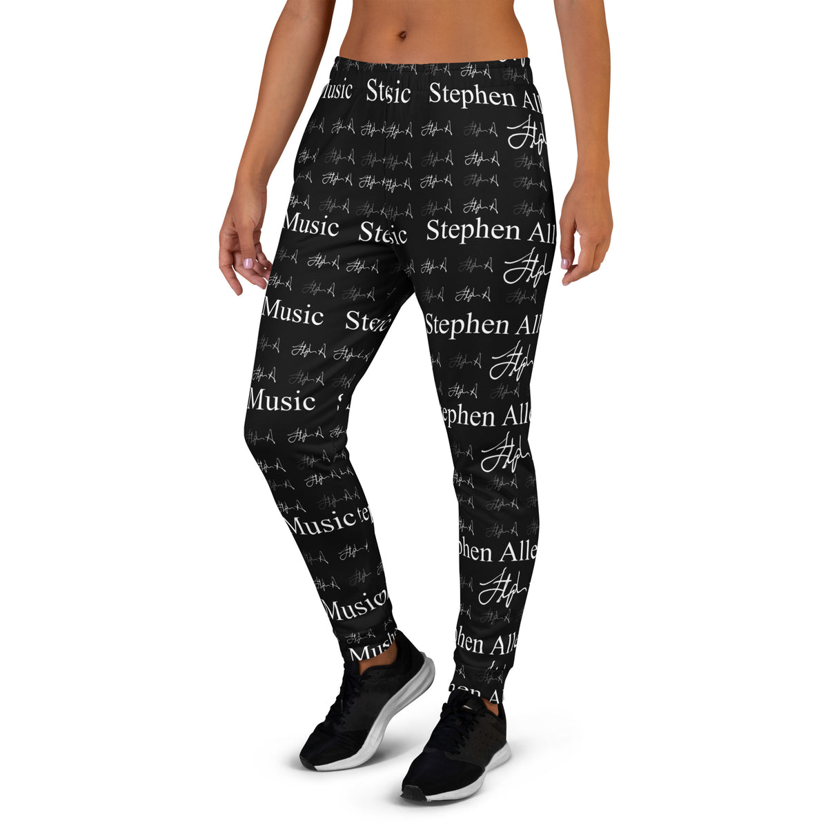 A person wearing black jogger-style pants with an allover white 'Stephen Allen Music' text and script print, shown from the waist down against a plain white background.